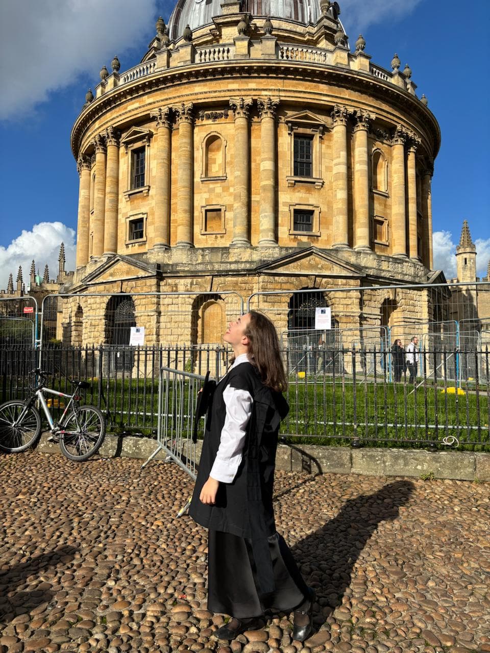 Студентка в академической мантии у Radcliffe Camera, Oxford